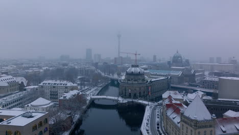 Descending-footage-of-landmarks-in-city-centre.-Winter-aerial-shot-of-Bode-Museum-on-Spree-river-waterfront.-Berlin,-Germany