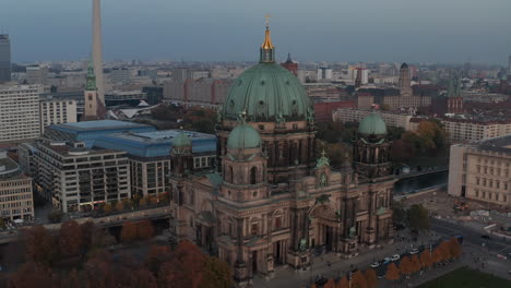 Fly-around-Berlin-cathedral,-richly-decorated-historic-landmark-at-dusk.-DDR-Museum-building-behind.-Berlin,-Germany
