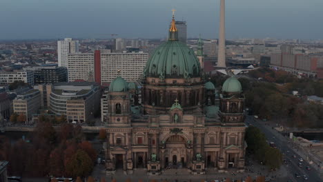 Slide-and-pan-footage-of-Berlin-cathedral-at-dusk.-Large-church-with-dome-roof-and-golden-religious-cross-on-top.-Berlin,-Germany
