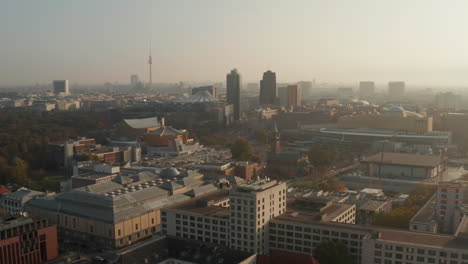 Forwards-fly-above-Tiergartenviertel-urban-district.-Aerial-panoramic-footage-of-buildings-in-town,-Fernsehturm-TV-tower-in-distance.-Berlin,-Germany