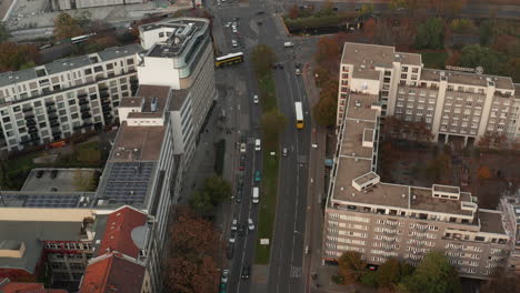 Forwards-tracking-of-bus-driving-on-multilane-road-through-town.-High-angle-view-of-traffic-on-intersection.-Berlin,-Germany