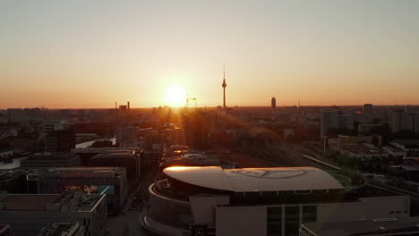 Berlin,-Deutschland-Bei-Schönem-Sonnenuntergang,-Sonnenlicht,-Goldene-Stunde-Und-Blick-über-Den-Alexanderplatz,-Fernsehturm-Und-Mercedes-Benz-Arena-Mit-Blinkenden-Reklamen,-Sonnenflairs-über-Den-Dächern-Im-Jahr-2019