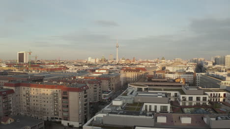 AERIAL:-Low-over-Berlin-Central,-Mitte-with-view-on-Alexanderplatz-TV-Tower-on-beautiful-sunny-day