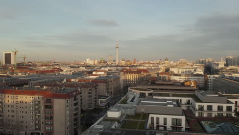AERIAL:-Low-over-Berlin-Central,-Mitte-with-view-on-Alexanderplatz-TV-Tower-on-beautiful-sunny-day