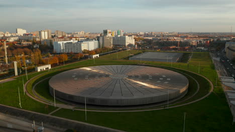 Establishing-Shot-above-Futuristic-Velodrome-Building-cycling-Arena-in-Berlin,-Germany,-Aerial-view-at-Sunset