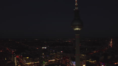 Wolkenkratzerturmgebäude-Mit-Breitem-Stadtbild-Bei-Nacht-Im-Hintergrund-Mit-Leuchtenden-Lichtern-Und-Gebäuden-In-Berlin,-Deutschland-Im-Jahr-2019