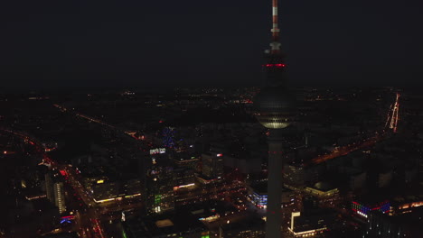 Fernsehturm-Blinkt-Rot-Blinkendes-Licht-Mit-Stadtlichtern-Der-Großen-Metropolregion-Im-Hintergrund,-Luftdrohnenaufnahme