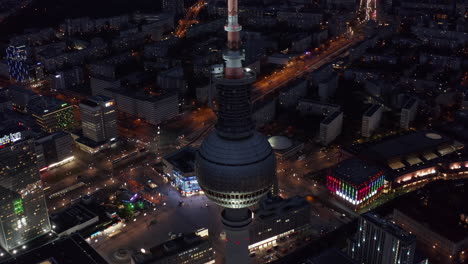 Vista-Asombrosa-De-Un-Impresionante-Rascacielos-En-El-Centro-Urbano-Rodeado-De-Luz-De-La-Ciudad-Y-Calles-Con-Edificios-En-Berlín,-Alemania,-Toma-Aérea-Que-Establece-Un-ángulo-Amplio