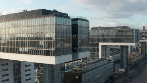 Backwards-reveal-of-buildings-on-waterfront-in-city.-Crane-houses,-design-residential-buildings-in-former-harbour.-Cologne,-Germany