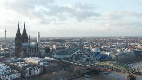Aerial-panoramic-footage-of-busy-railway-line-at-main-train-station-next-to-Cologne-Cathedral.-Cologne,-Germany