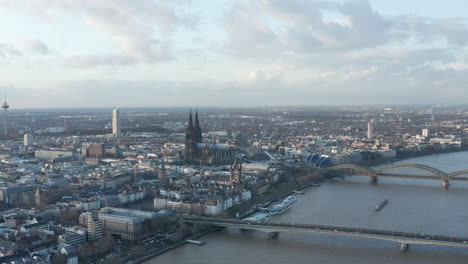 Aerial-panoramic-footage-of-city-landmarks.-Old-town-with-Cathedral-Church-of-Saint-Peter-at-dusk.-Cologne,-Germany