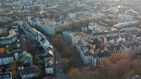 Aerial-drone-view-on-urban-neighbourhood.-Tilt-up-footage-revealing-skyline.-Cityscape-with-tall-modern-skyscrapers-against-sun.-Frankfurt-am-Main,-Germany