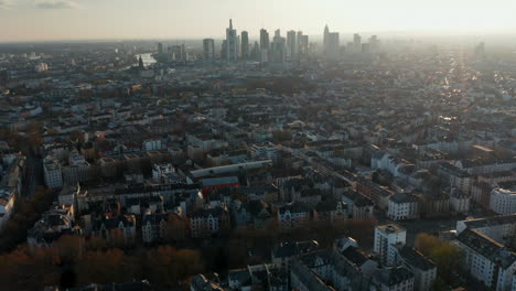 Aerial-drone-view-of-large-city-against-bright-sky.-Tilt-up-revealing-skyline.-Cityscape-with-skyscrapers-downtown.-Frankfurt-am-Main,-Germany