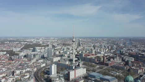 AERIAL:-Super-Close-Up-View-Circle-around-the-Alexanderplatz-TV-Tower-in-Berlin,-Germany-on-hot-summer-day