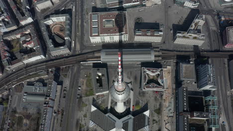 Antenne:-Super-Nahansicht-Der-Spitze-Des-Alexanderplatz-Fernsehturms-Mit-Berlin,-Deutschland-Straßen-Im-Hintergrund-An-Heißen-Sommertagen