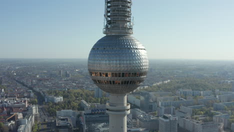 AERIAL:-Wide-View-of-the-top-of-Alexanderplatz-TV-Tower-with-Empty-Berlin,-Germany-Streets-in-background-on-hot-summer-day-during-COVID-19-Coronavirus-Pandemic