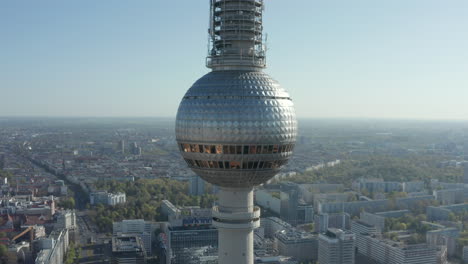 Antena:-Amplia-Vista-De-La-Parte-Superior-De-La-Torre-De-Televisión-Alexanderplatz-Con-Calles-Vacías-De-Berlín,-Alemania-En-Segundo-Plano-En-Un-Caluroso-Día-De-Verano-Durante-La-Pandemia-Del-Coronavirus-Covid-19