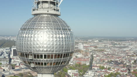 AERIAL:-Super-Close-Up-View-Circle-around-the-Alexander-Platz-TV-Tower-in-Berlin,-Germany-on-hot-summer-day