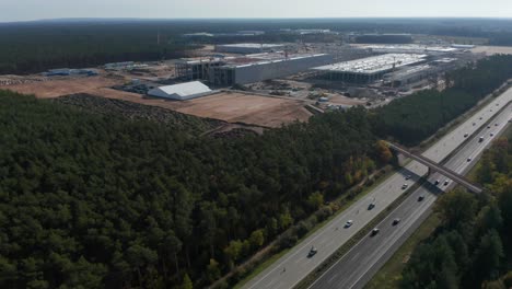 Big-Factory-Structure-under-construction-in-rural-landscape-of-Germany-near-Berlin,-Gigafactory-by-Tesla