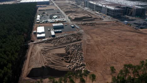 Establishing-Shot-of-a-Big-Construction-Site-in-rural-area-with-Dirt-and-Sand-for-building-a-factory,-Aerial-View
