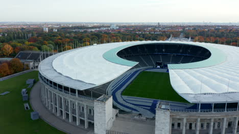 Majestic-Olympia-Stadium-entrance-with-view-of-empty-grandstand-seating-row-with-no-people-during-Coronavirus-Covid-19-Pandemic,-Aerial-Wide-Establishing-Shot,-October-2020