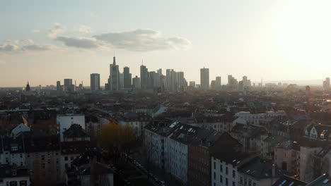 Aerial-drone-view-of-large-city-against-bright-sky.-Drone-flying-towards-group-of-skyscrapers-downtown.-Skyline-of-business-and-financial-centre.-Frankfurt-am-Main,-Germany