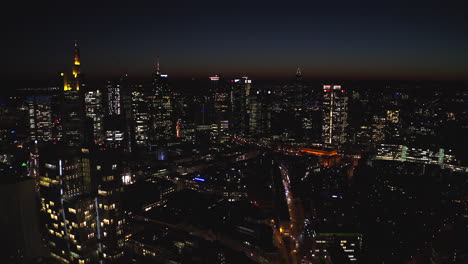 Frankfurt,-Germany-Skyline-at-Night,-beautiful-Aerial-tilt-up-revealing-big-metropolitan-area-with-Skyscrapers-and-Street-lights