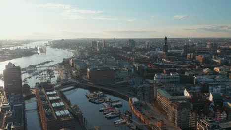 Aerial-ascending-view-of-Hamburg-port-with-boats-on-river-Elbe-and-apartment-buildings-on-the-river-bank