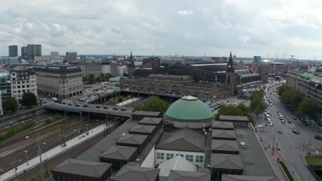Flying-around-Hamburg-Hauptbahnhof-train-station.-Multiple-railroad-tracks-with-turnouts-and-busy-streets-next-to-station.-Free-and-Hanseatic-City-of-Hamburg,-Germany