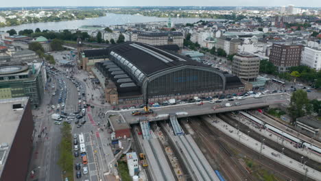 Descending-footage-of-traffic-in-city.-Aerial-view-of-Hamburg-Hauptbahnhof-train-station-and-busy-roads-around.-Free-and-Hanseatic-City-of-Hamburg,-Germany