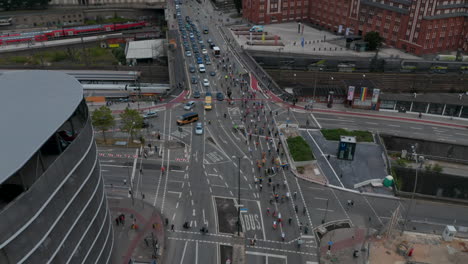 Ascending-view-of-group-of-cyclists-riding-on-multilane-road-through-intersection.-Aerial-view-of-demonstrating-or-celebrating-people.-Free-and-Hanseatic-City-of-Hamburg,-Germany