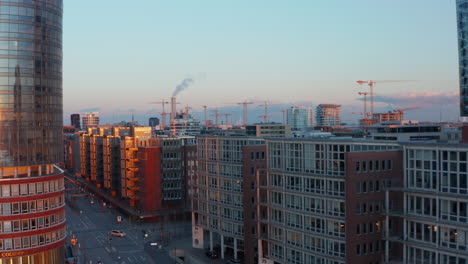 Reveal-of-traffic-on-scarce-city-street-surrounded-by-modern-apartment-buildings-in-urban-city-center-of-Hamburg