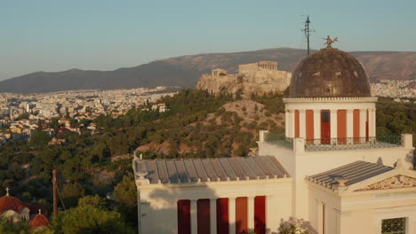 Antenne,-Die-Am-Nationalen-Observatorium-Von-Athen-Vorbeifährt-Und-Die-Akropolis-In-Einer-Wunderschönen-Goldenen-Stunde-Enthüllt