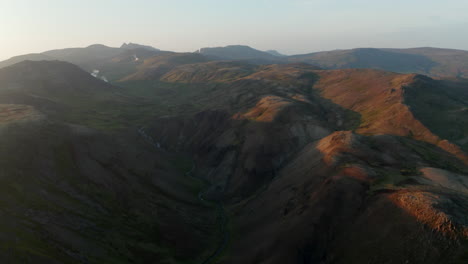 Drohnen-Schieberegler-über-Spektakuläre-Landschaften-In-Island.-Vogelperspektive-Des-Bemoosten-Hochlandes-Mit-Dampfenden-Fumarolen-Im-Hintergrund