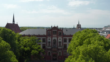 Nach-Hinten-Ansteigende-Leibung-Gewachsener-Bäume-Auf-Kleinem-Platz-Vor-Historischem-Universitätsgebäude-Und-Umliegenden-Straßen