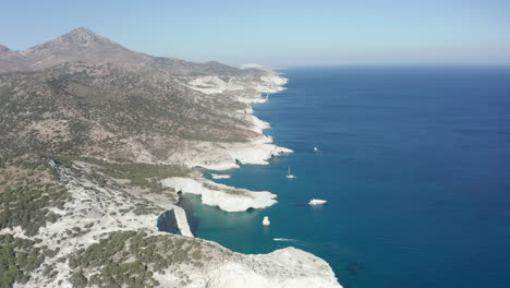 Aerial-Wide-Dolly-Vor-Der-Küste-Mit-Weißen-Felsen-Und-Booten-Im-Ozean