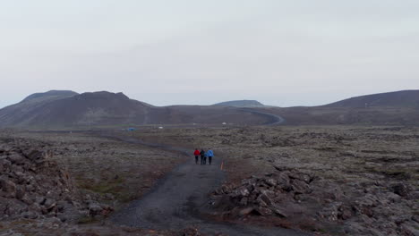 Aerial-view-of-tourist-hikers-discovering-exploring-Iceland-countryside.-Drone-view-four-people-tourist-mountaineering-hiking-in-icelandic-nordic-highlands
