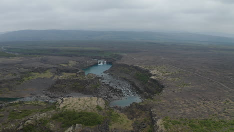 Aerial-view-of-famous-waterfall-of-Aldeyjarfoss-situated-in-the-northern-part-of-the-Sprengisandur-Road-in-icelandic-highlands.-Drone-view-of-stunning-basalt-and-rocky-countryside-in-north-iceland