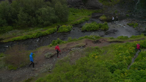Drohnenansicht-Zwei-Trekkingtouristen,-Die-Die-Wildnis-Des-Isländischen-Hochlandes-Erkunden-Und-Am-Flussufer-Spazieren-Gehen.-Luftbild-Sportlicher-Reisender,-Der-Den-Wasserfall-Aldeyjarfoss-In-Nordisland-Entdeckt