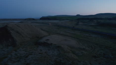 Drone-view-of-highway-car-peacefully-driving-on-ring-road-at-evening.-Birds-eye-view-car-fast-driving-on-ring-road,-the-most-important-highway-in-Iceland