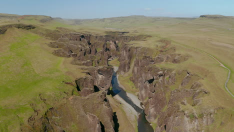 Drone-view-of-unique-landscape-of-Fjadrargljufur-canyon-in-Iceland.-Beautiful-landscape-view-of-river-and-mountain-with-rocky-formation-covered-moss.-Amazing-on-earth.-Fjadrargljufur-canyon