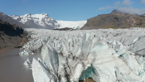 Vista-Aérea-De-Icebergs-Nadando-En-El-Lago-Glaciar-Breidamerkurjokull-En-El-Parque-Nacional-Vatnajokull,-Islandia.-Laguna-Glaciar-Con-Grandes-Bloques-De-Hielo,-Derritiéndose-Y-Resquebrajándose-Del-Glaciar-Principal