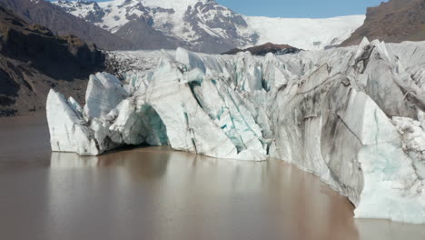 Vista-Aérea-Del-Iceberg-Flotante-Del-Glaciar-Breidamerkurjokull-En-El-Sur-De-Islandia.-Vista-De-Drones-De-La-Lengua-Del-Glaciar-Y-Montañas-Nevadas-En-El-Parque-Nacional-Vatnajokull.-Glaciar-Breidamerkurjokull