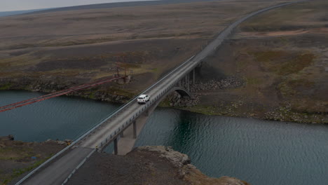 Luftaufnahme-Einer-Brücke-über-Einen-Fluss,-Der-Durch-Das-Isländische-Hochland-Fließt.-Drohnenansicht-Auto-Fährt-über-Brücke-Mit-Frischem-Wasser-Darunter.-Island-Landschaft