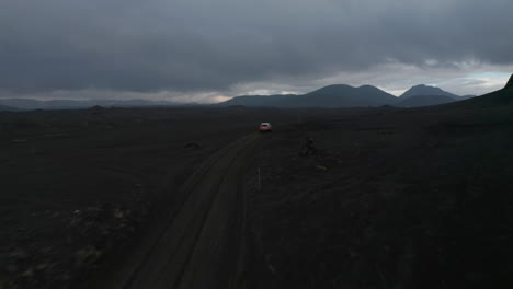 Birds-eye-view-car-travelling-alone-on-path-way-through-wilderness-of-icelandic-landscape.-Aerial-view-4x4-vehicle-exploring-Iceland-remote-destination.-Safety-and-security.-Adventure-and-exploration