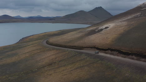 Aerial-view-of-glacier-lake-of-Skaftafell-national-park-with-offroad-jeep-driving-dirt-road-exploring-wilderness-icelandic-countryside.-Birds-eye-view-of-adventurous-Iceland-highlands
