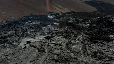 Low-flights-above-piles-of-accumulated-material-in-cooling-lava-stream.-Layer-of-erupted-volcanic-material.-Fagradalsfjall-volcano.-Iceland,-2021