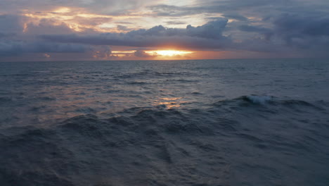 Kleine-Wellen-Auf-Der-Meeresoberfläche-Im-Warmen-Abendlicht.-Blauer-Ozean-Im-Orangefarbenen-Abendlicht-In-Bali