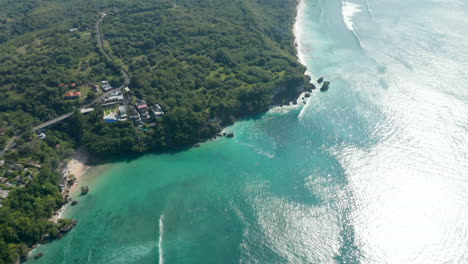 Aerial-panoramic-view-of-Bali-coastline-with-luxury-villas-and-lush-green-vegetation-by-the-sea