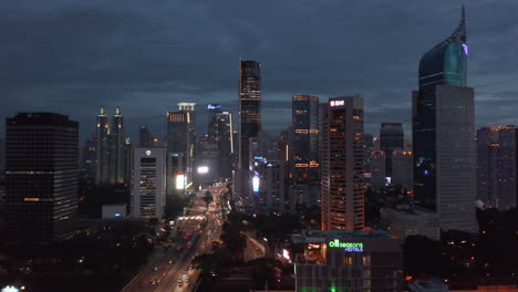 Aerial-dolly-shot-of-slow-night-traffic-on-multi-lane-highway-through-Jakarta-city-center